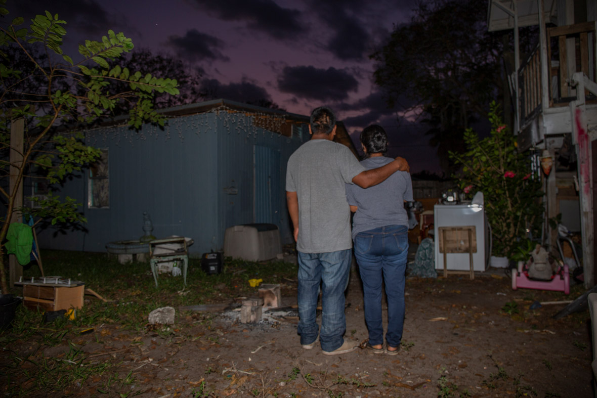 migrant couple standing under night sky, arm in arm