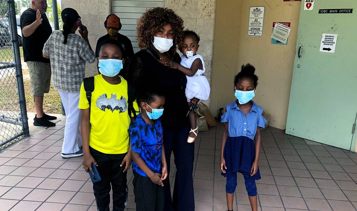 mother and 4 children posing for camera with masks
