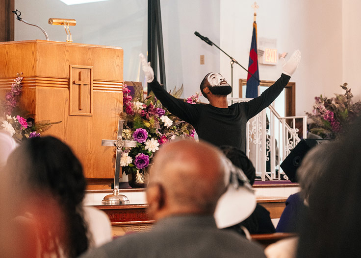 a man in the dress of a mime in a church