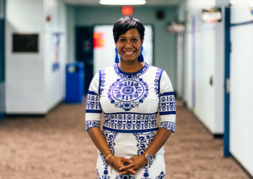 a woman in a blue and white dress posing and smiling