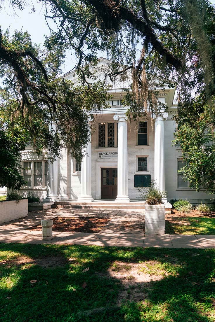 large, old white and brick building with round columns