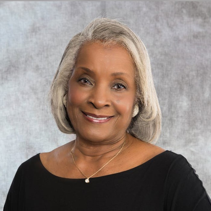 woman smiling in front of gray background