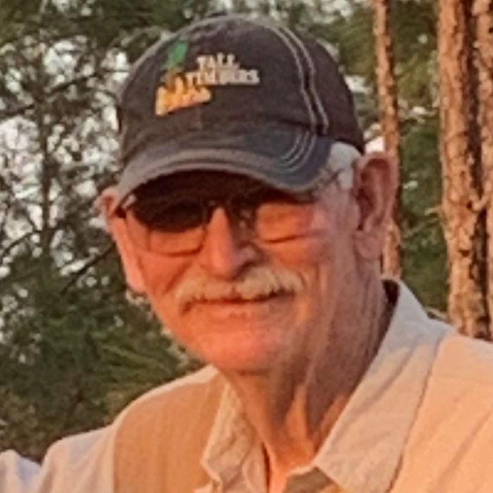 Smiling man in baseball cap.