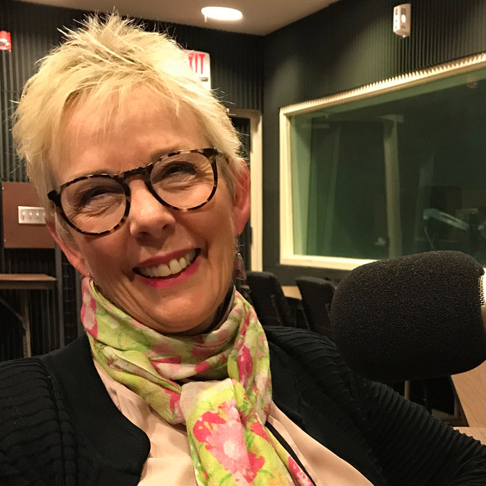 Susan Fiorito smiling in front of the microphone