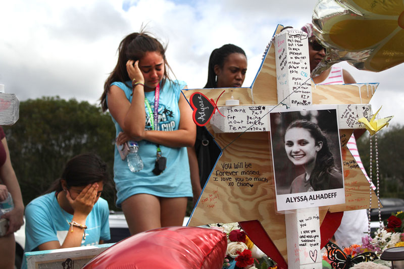 two young women crying while looking at makeshift memorial of alyssa alhadeff after shooting at marjory stoneman douglas high school in parkland, florida