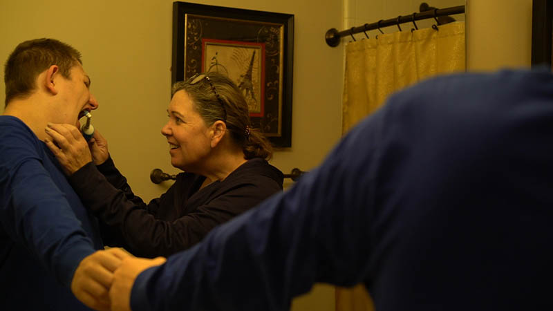 Denise helps Brady practice good dental hygiene